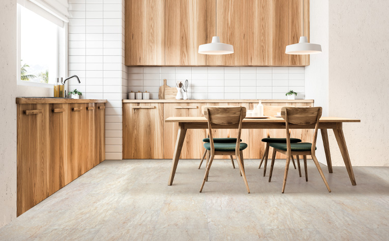 stone look luxury vinyl tile flooring in kitchen with wood cabinetry and wood dining table with matching chairs